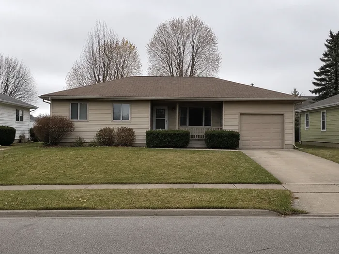 A phone held up in front of a suburban house, framing the whole facade from the pavement
